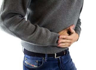 Mann hält sich am Bauch